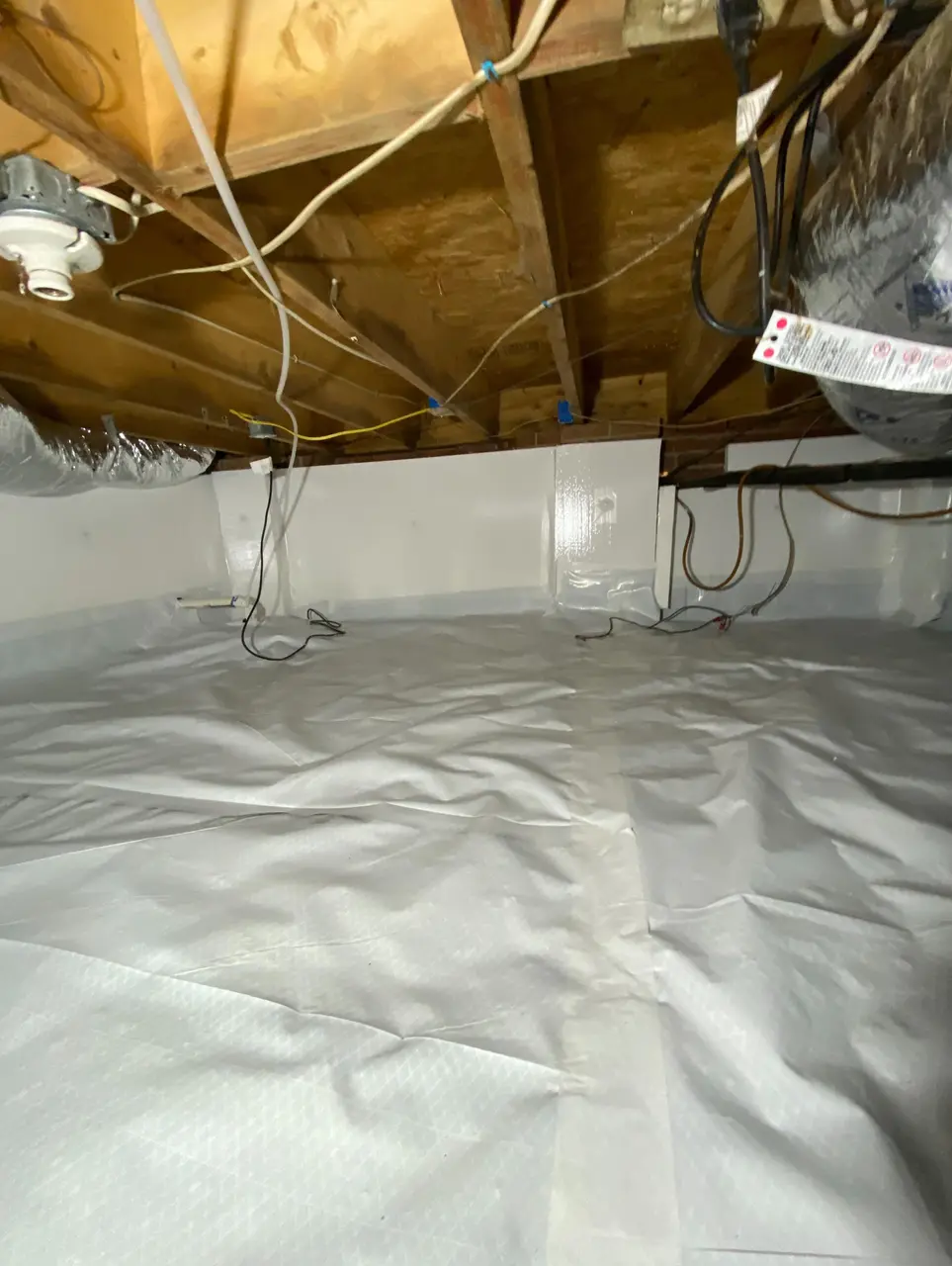 Encapsulated crawlspace corner with sealed vapor barrier and wiring left accessible