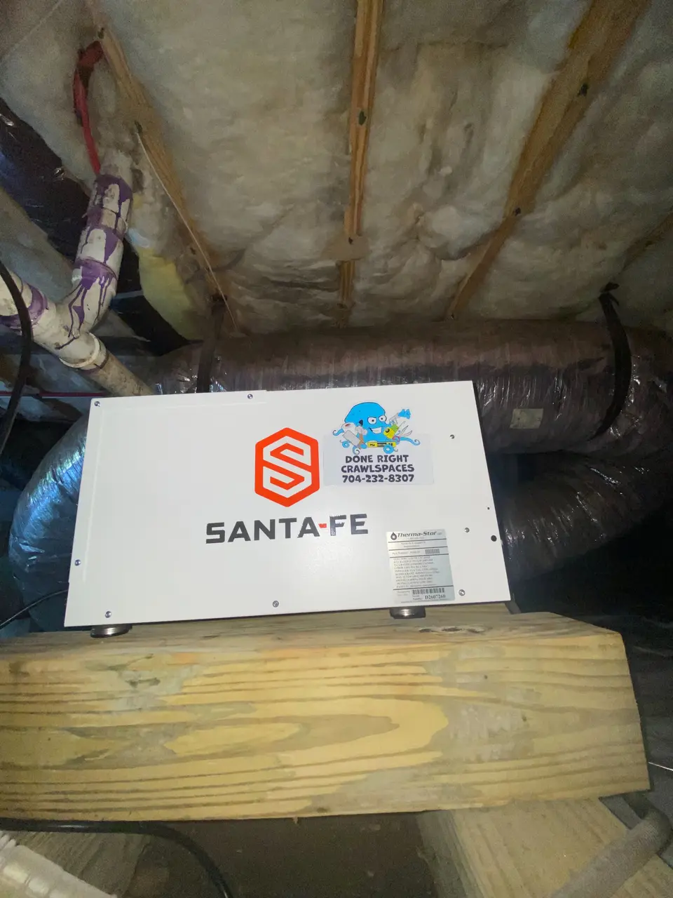 Santa Fe dehumidifier installed on a support beam inside a crawlspace