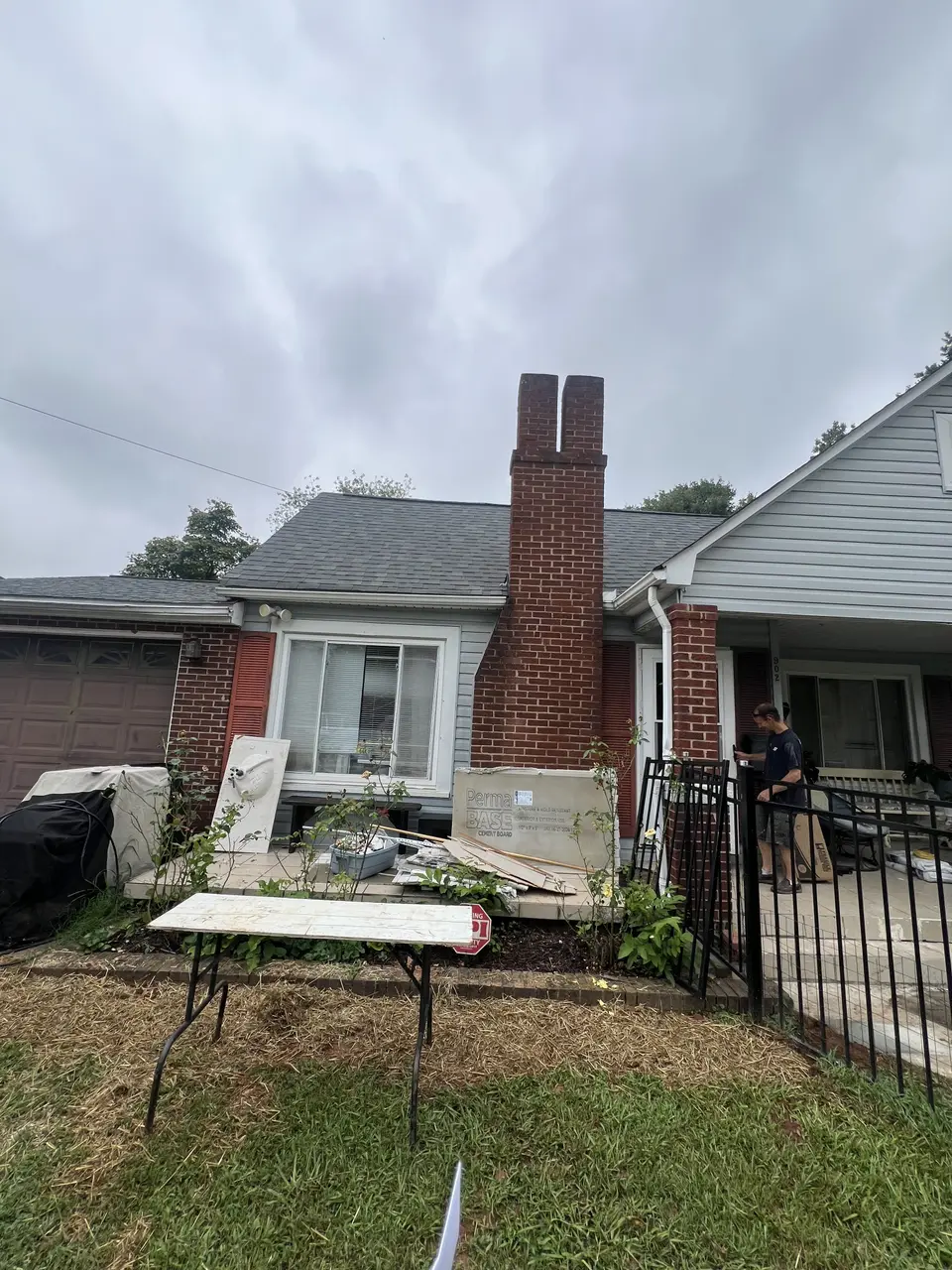 Front of the home with cement board materials staged for exterior wall work
