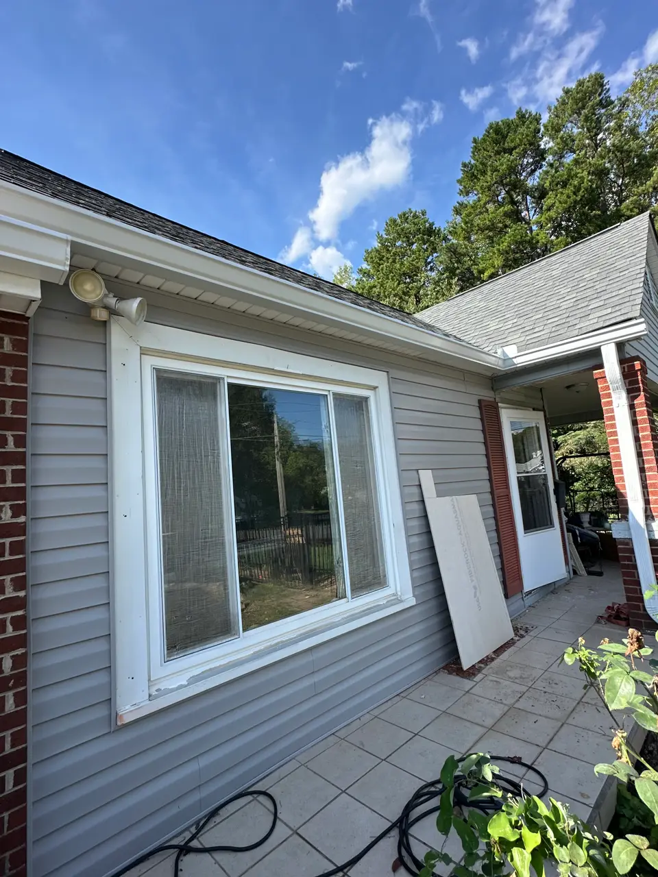 Closer view of the wall opening near the window with cement backer board staged during exterior work