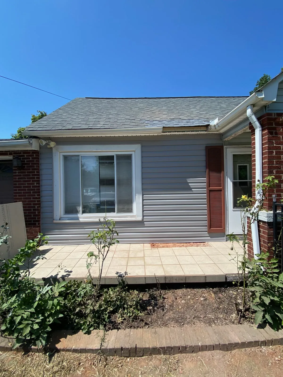 Rear wall and patio area of the home following exterior wall preparation work